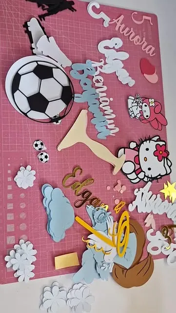 Diversos personalizados sobre mesa rosa: nomes, Hello Kitty, bola de futebol e nuvens